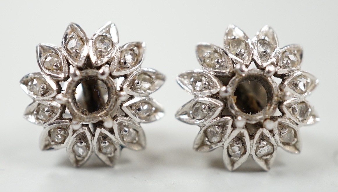 A cased pair of white metal and diamond cluster set flower head ear studs, both lacking centre stone, diameter 13mm, gross weight 4.4 grams.
